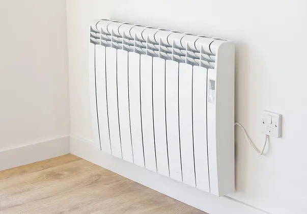 Radiateur électrique blanc fixé au mur d'une pièce avec parquet.