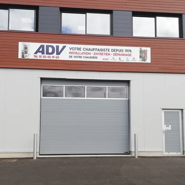 Façade d'un bâtiment commercial avec un grand garage et une pancarte ADV.